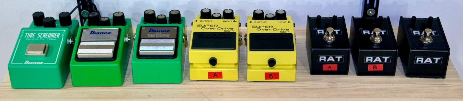 The eight measured pedals on the bench, left to right: an Ibanez TS808 Tube Screamer; two Ibanez TS9 Tube Screamers, unit A (new) and unit B (used, on loan); two BOSS SD-1 Super OverDrives, units A and B; three LiL' Rat pedals, units A and B (new) and unit C (used, on loan).